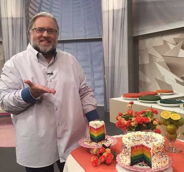Leão Lobo posa com bolo feito pela Chef Gita e brinca dizendo que é "homenagem à minha querida comunidade LGBT por causa das cores"